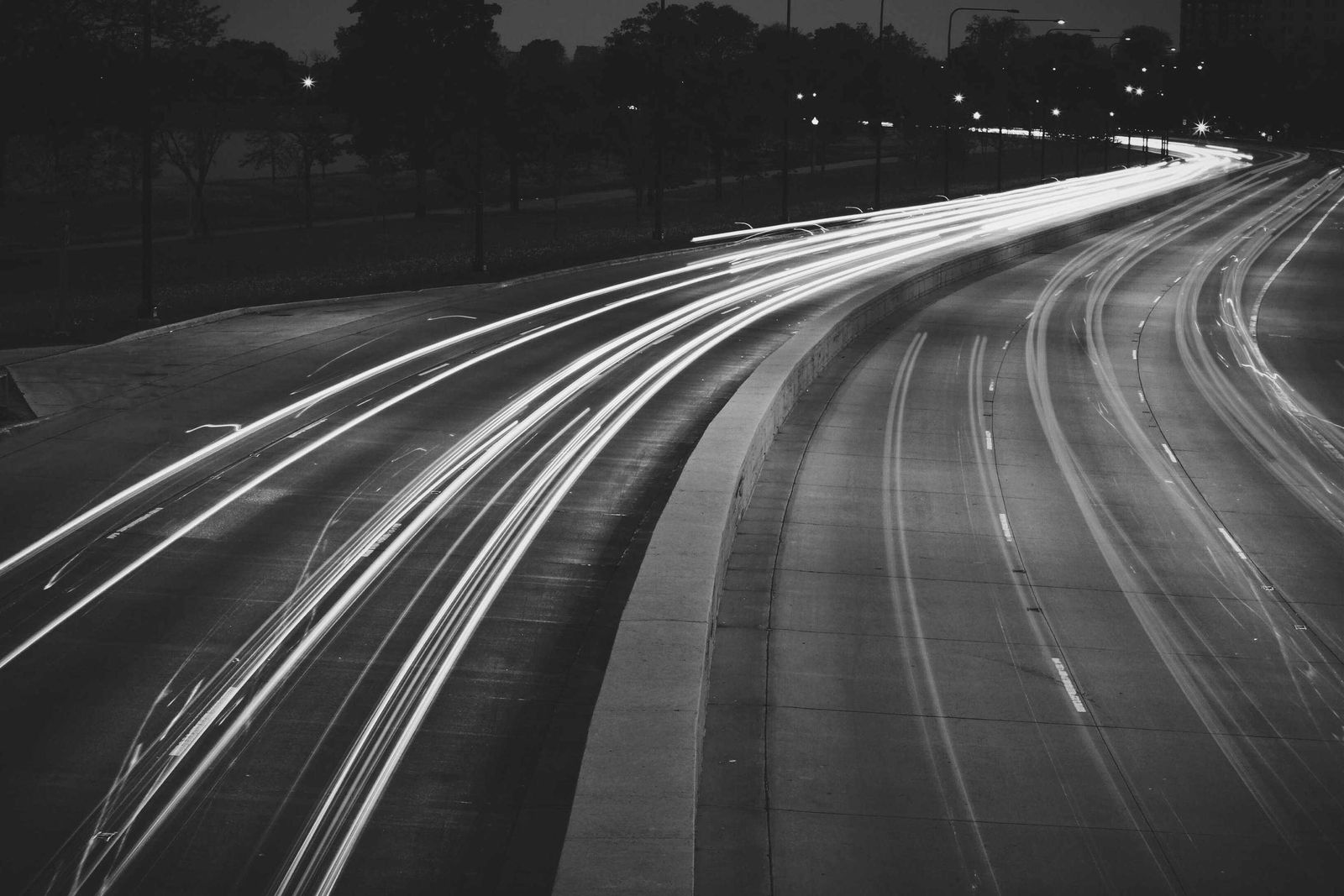 Autopista de noche con estelas de luz que dejan los autos en movimiento